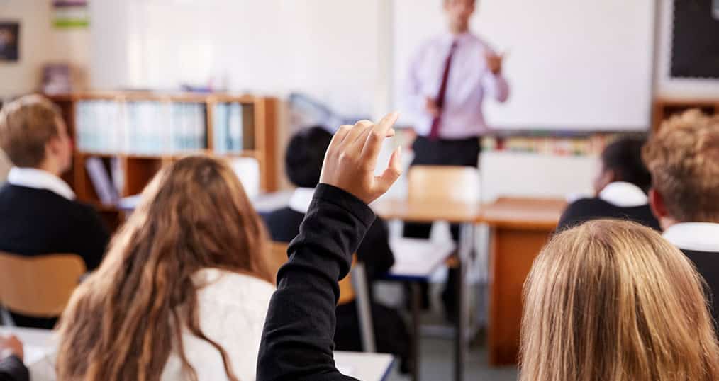 GCSE Student raising their hand in the classroom