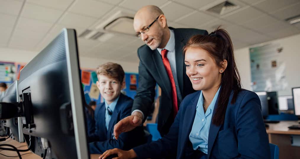GCSE Teacher showing students content on a computer